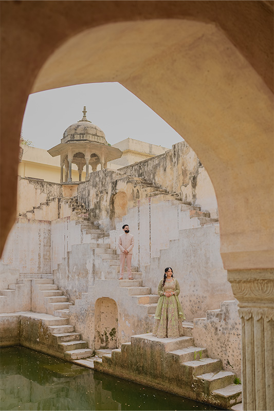 Regal couple posing on the symmetrical steps of Panna Meena Kund stepwell in Jaipur