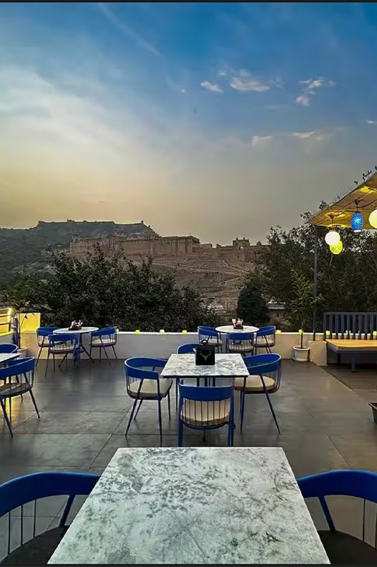 Romantic couple having tea in front of Amer Fort view from Stag Cafe